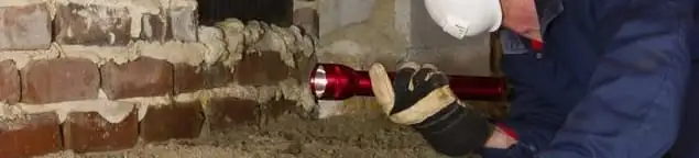 Pest control technician inspecting a crawl space for ant activity and entry points in Oakland, CA