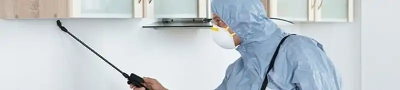 Termite treatment technician applying indoor pest control spray in Oakland, CA